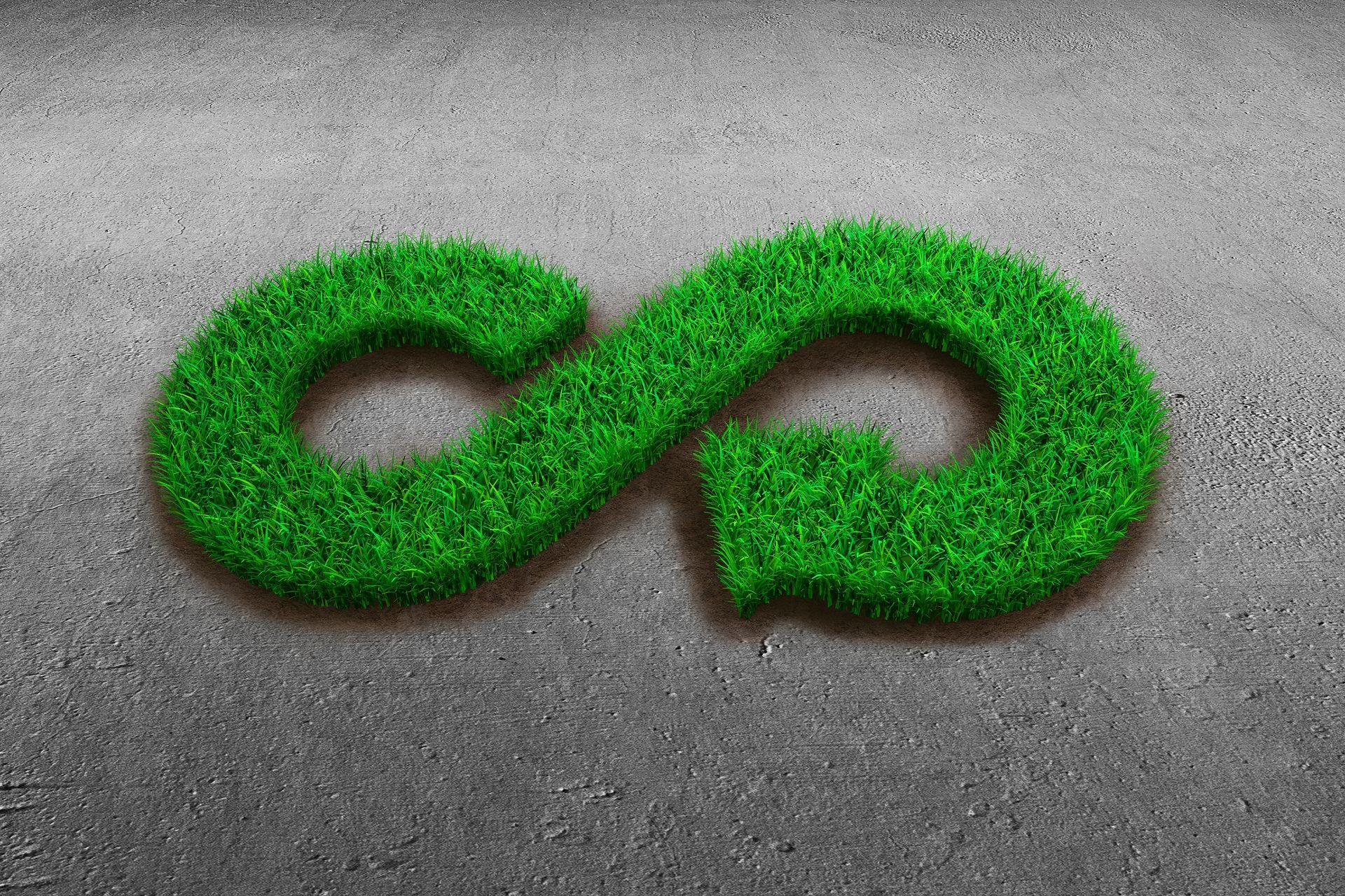 ECO and circular economy concept. The green grass in form of arrow infinity recycling symbol on concrete floor background.